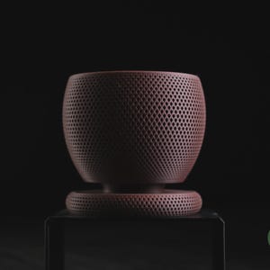 Puede incluir: Una maceta en forma de cuenco de color granate oscuro con una textura de celos&iacute;a de patr&oacute;n de diamante uniforme en toda su superficie exterior. La maceta se asienta sobre una base circular a juego con el mismo dise&ntilde;o perforado. Texto h3li&oslash; design.