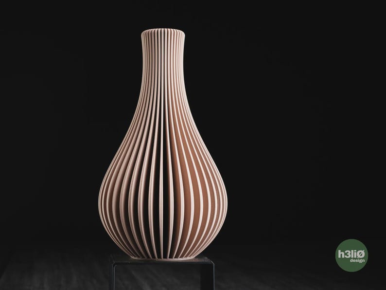 May include: A light peach-coloured vase with a vertical ribbed texture and a narrow neck that flares into a rounded base. The vase features a repeating pattern of thin, deep grooves along its entire exterior surface. The text h3li&oslash; design is visible.
