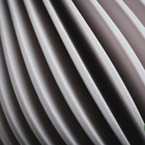 May include: A series of repeating, curved, light grey vertical panels creating a rhythmic, wave-like pattern. The surface of each panel has a fine, textured finish. A small circular green logo in the bottom right corner displays the text h3li&oslash; design.