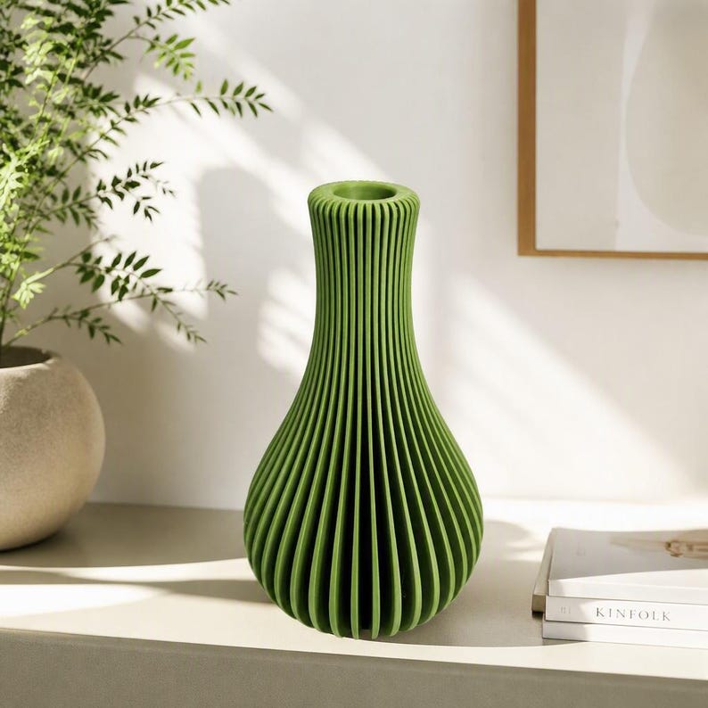 May include: A bright green vase with a vertical ribbed texture and a narrow neck. The vase has a rounded, bulbous body that tapers upwards to a circular opening, featuring a consistent pleated design throughout its entire exterior surface.