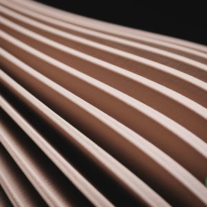 May include: A series of parallel, light beige, curved ridges arranged in a repeating pattern that recedes into the distance. The surface has a smooth, matte texture. A small, circular green logo with the text h3li&oslash; design is in the corner.