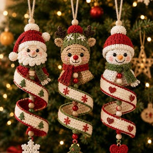 May include: Three crocheted Christmas ornaments featuring a Santa Claus, a reindeer, and a snowman. Each figure wears a hat and scarf, attached to a spiraling cream-colored ribbon with festive motifs, wooden beads, and a dangling bottom charm.