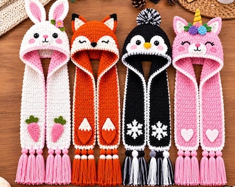 May include: Four crochet hooded scarves featuring animal designs: a white rabbit with pink accents and carrots, an orange fox, a black and white penguin with snowflakes, and a pink unicorn with a gold horn and floral details.