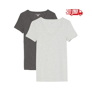 Könnte beinhalten: Ein Set aus zwei kurzärmeligen T-Shirts mit V-Ausschnitt. Ein Shirt ist in Dunkelgrau gehalten, das andere in einem hellen Graumeliert. Beide Kleidungsstücke haben ein schlichtes, einfarbiges Design mit kurzen Ärmeln und einem Standard-Saum.