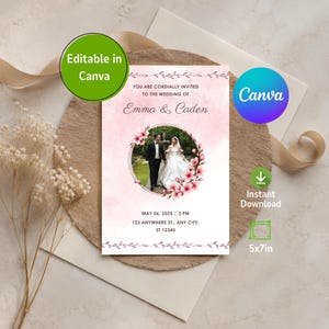 May include: A rectangular wedding invitation template with a soft pink watercolor background, featuring a central circular photo frame adorned with pink floral illustrations. The text reads: YOU ARE CORDIALLY INVITED TO THE WEDDING OF Emma & Caden, MAY 06, 2025 | 3 PM, 123 ANYWHERE ST., ANY CITY, ST 12345.
