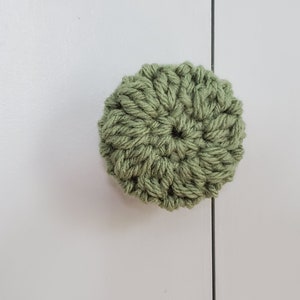 May include: A green crocheted knob for a cabinet or drawer.