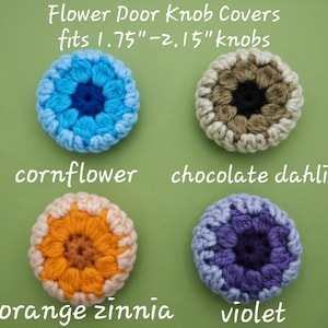 May include: Four round, crocheted flower door knob covers that fit 1.75"-2.15" knobs. The colors include a blue cornflower, a brown and cream chocolate dahlia, an orange and peach orange zinnia, and a purple and light purple violet design.