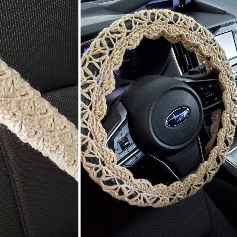 May include: A beige crochet steering wheel cover and matching seat belt cover. The steering wheel cover is circular with an openwork design. The seat belt cover is a long, cylindrical shape. Both items are made of a textured, woven material.