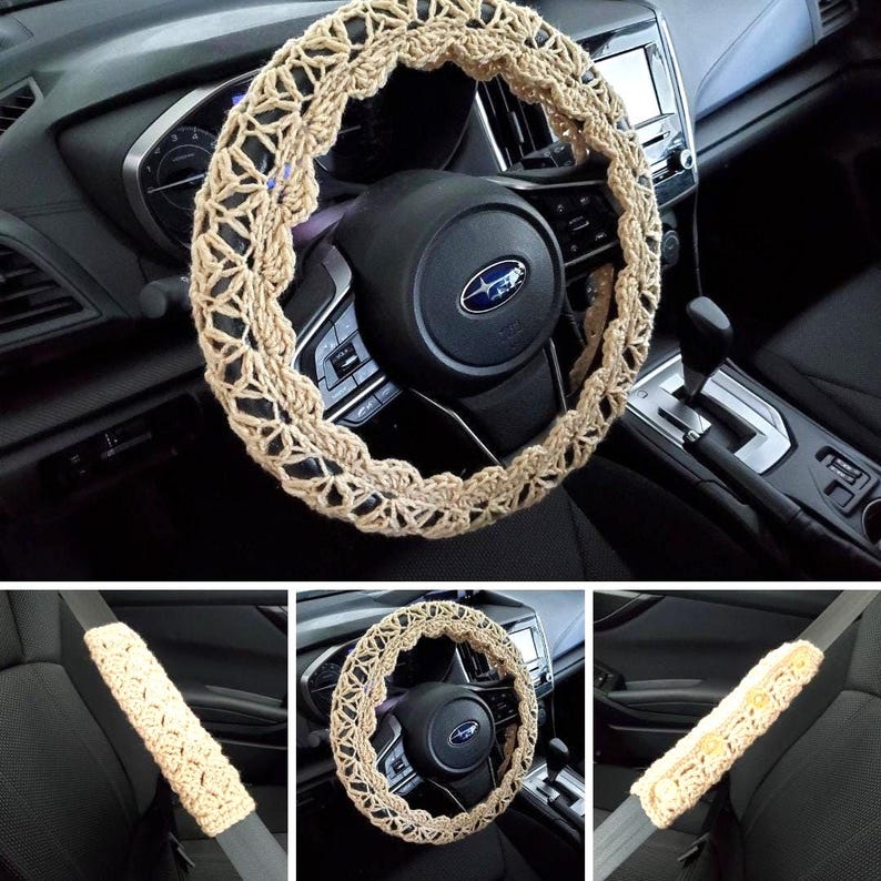 May include: Beige crochet steering wheel cover and matching seatbelt covers. The steering wheel cover is circular with an openwork design. The seatbelt covers are rectangular with button details. The items are shown in a car interior.