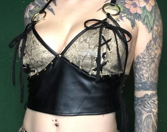 Top de piel sintética con estampado de serpiente y tachuelas metálicas.
