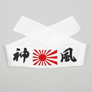 May include: A white fabric headband featuring black Japanese kanji characters on the left and right sides, with a central red sun graphic displaying radiating rays. The headband is folded into a cross shape, showcasing its clean, minimalist design.