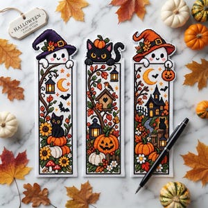 Może przedstawiać: Trzy prostokątne zakładki do książek wykonane haftem krzyżykowym z motywami Halloween. Po lewej duch w fioletowym kapeluszu, w środku czarny kot z budką dla ptaków, po prawej duch w pomarańczowym kapeluszu i nawiedzony dom. Każda zawiera dynie.