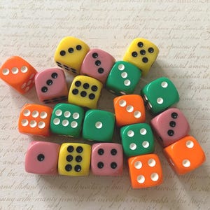 May include: A collection of colorful dice in shades of orange, pink, yellow, and green. Each die features white dots indicating numbers. These dice are perfect for board games and tabletop gaming.