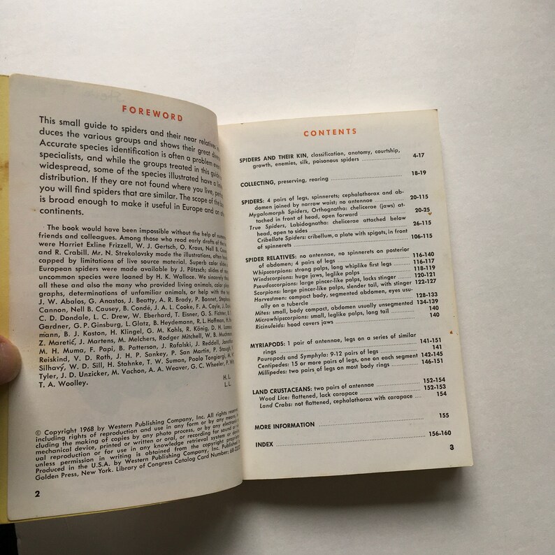 May include: An open book with a yellow spine showing pages 2 and 3. The left page features a foreword with black text, while the right page displays a table of contents titled Contents, listing sections on spiders, myriapods, and land crustaceans.