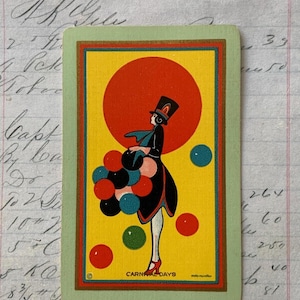 May include: Vintage playing card featuring a stylized illustration of a figure in a black outfit and top hat, holding colorful balloons against a yellow background. The card has a green border and the text "CARNAL DAYS".