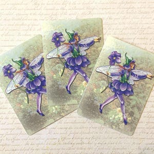 May include: Three vintage-style cards featuring a fairy illustration. The fairy is depicted in a purple and green outfit, holding a flower. The background has a soft, faded green and beige color scheme, with a hint of script.