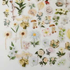 以下が含まれることがあります： 花、葉、キノコなど、さまざまな花柄の白いステッカーのシートです。ジャーナル、プランナー、その他のクラフトプロジェクトに遊び心を加えるのに最適です。