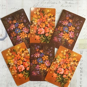 May include: Six vintage cards with a floral bouquet design. The bouquets are painted in shades of orange, pink, yellow, blue, and purple. The cards have a brown background.