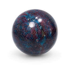 Può includere: Una pietra sferica lucida caratterizzata da una consistenza marmorizzata con colorazioni blu intenso e rosso scuro. La superficie è liscia e riflettente, mostrando inclusioni minerali naturali e variazioni su tutta la forma rotonda.