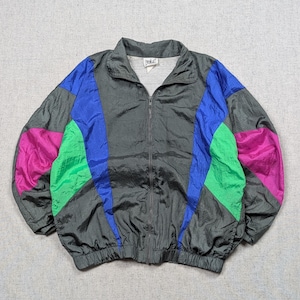 May include: A charcoal gray zip-up windbreaker jacket featuring a color-blocked design with vibrant blue, bright green, and magenta panels. The jacket has a high collar, long sleeves with elastic cuffs, and an Everlast brand label at the neck.