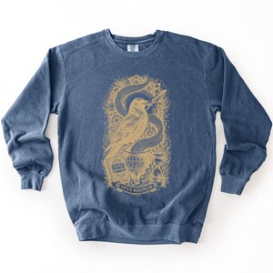 Navy blue programmer gift sweatshirt featuring a beige alchemy streetwear graphic of a raven.