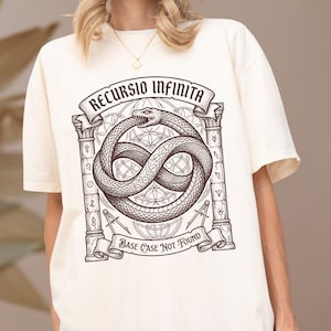 以下が含まれることがあります： オフホワイトのTシャツで、インフィニティシンボルを形成するウロボロスの蛇のダークブラウンのグラフィックが描かれています。デザインには2本の柱、幾何学模様が含まれ、上部に「RECURSIO INFINITA」、下部に「BASE CASE NOT FOUND」というテキストが配置されています。