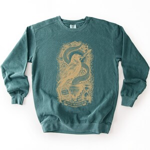 Pine green tech humor sweatshirt displaying a dark red vintage bird art print with a cauldron of binary code.