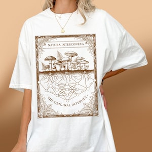 White nature tech t-shirt worn by a woman, showing a brown mycology geometry graphic.
