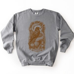 Light grey gothic tech clothing sweatshirt showcasing a brown vintage raven and clockwork illustration.