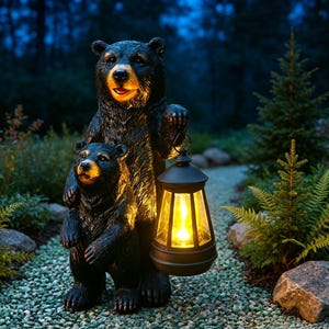 Könnte beinhalten: Eine schwarze Bärenstatue mit einem großen erwachsenen Bären, der hinter einem kleineren Jungtier steht. Der erwachsene Bär hält eine schwarze Laterne in einer Pfote, die ein warmes, gelbes Licht ausstrahlt. Die Bären haben strukturiertes Fell und hellbraune Schnauzen.