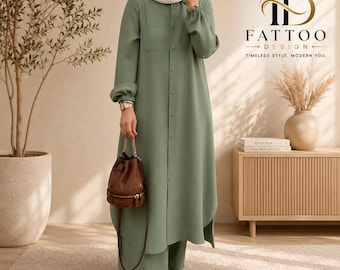 May include: A sage green long-sleeved button-down tunic dress with a chest pocket and gathered cuffs, paired with matching wide-leg trousers. The outfit is accessorised with a brown leather drawstring bucket bag and a white headscarf.