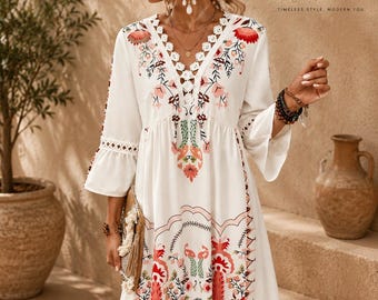 May include: A white knee-length dress featuring a V-neckline with white lace trim, three-quarter length bell sleeves, and a colourful floral and geometric print in shades of red, pink, green, and orange. The dress includes the text FATTOO.