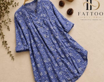 May include: A blue long-sleeve tunic shirt featuring a white floral pattern, a mandarin collar, and a full-length button-down front. The garment includes cuffed sleeves and a curved hemline. The text FATTOO DESIGN is visible in the upper right corner.