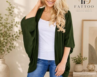 May include: A dark olive green open-front cardigan with three-quarter length kimono-style sleeves, worn over a plain white tank top and blue denim jeans. The garment features a loose, draped fit and a solid, smooth fabric texture throughout.