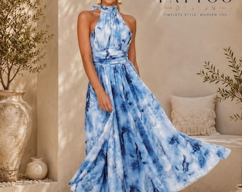 May include: A sleeveless halter-neck maxi dress featuring a blue and white watercolour-style abstract print, a fitted bodice with a gathered waistline, and a flowing, pleated skirt that falls to the ankles, crafted from a lightweight, semi-sheer fabric.