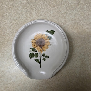 Reposacucharas de cerámica estilo cuchara, color blanco rústico con motivo de girasol.