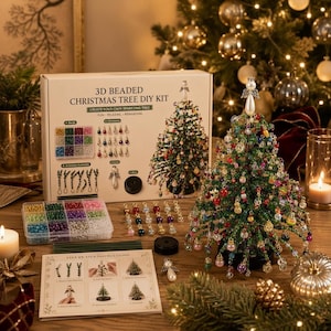 Pode incluir: Um kit de artesanato para árvore de Natal de contas 3D, incluindo uma caixa com instruções, um recipiente de plástico com contas multicoloridas, pingentes de metal, arame e uma árvore de contas verdes com um anjo branco no topo.