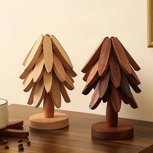 May include: Two decorative tree sculptures crafted from wood, each featuring a central trunk, a circular base, and multiple layered, petal-shaped wooden leaves. One tree is made of light-toned wood, while the other is constructed from a darker, rich brown wood.