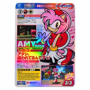 May include: A holographic trading card featuring Amy Rose from Sonic Adventure. The card displays Japanese text, a character illustration, and two game screenshots. It includes the text Amy Rose, Legendary Creature, Hedgehog Warrior, and 3/3.