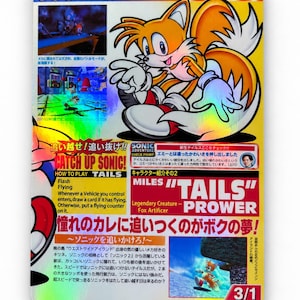 May include: A holographic trading card featuring the character Miles Tails Prower from Sonic Adventure. The card displays game screenshots, Japanese text, and English text including Miles Tails Prower, Legendary Creature Fox Artificer, and 3/1.