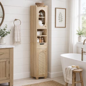 May include: A tall, light wood bathroom storage cabinet featuring an arched glass-paneled upper door, three open shelves, a single pull-out drawer, and a lower cabinet door with a woven rattan panel insert, standing on four small block feet.