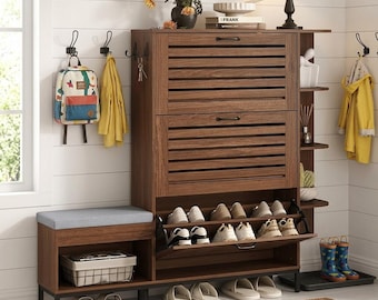 May include: A brown wooden entryway storage unit featuring a bench with a gray cushion, two slatted tilt-out shoe compartments, open side shelving, and a bottom shelf. The unit includes metal hooks for hanging items and a wire basket.