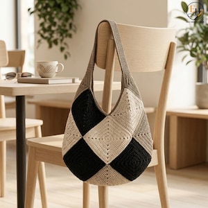 Può includere: Una borsa a spalla in stile hobo realizzata in filato all'uncinetto, caratterizzata da un motivo geometrico di quadrati alternati neri e color crema. La borsa include un unico cinturino integrato di colore beige tinta unita.