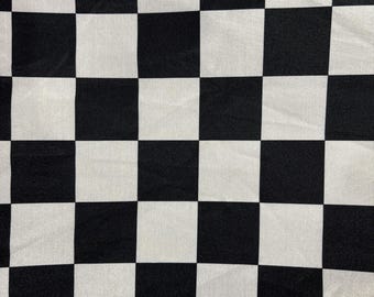 May include: Black and white checkered fabric with a subtle sheen. The fabric is smooth and has a woven texture.