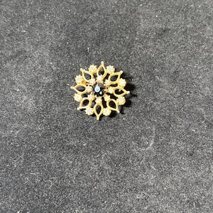 vintage starburst gold tone brooch with rhinestone
