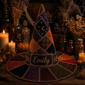 Puede incluir: Un sombrero cónico con un diseño de patchwork de telas oscuras en tonos morado, naranja, verde y negro. El sombrero incluye estrellas y una luna creciente bordadas, con el nombre Emily cosido en hilo dorado en la banda frontal.