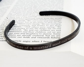 May include: A black metal bracelet with an engraved quote: "Faith the size of a mustard seed can move mountains".