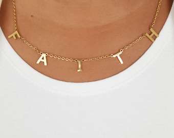 May include: Gold necklace with the word "FAITH" spelled out in individual letters.