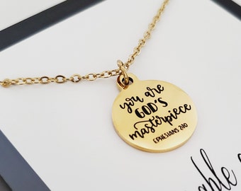 May include: Gold necklace with a round pendant that says "You are God's masterpiece" with the scripture reference "Ephesians 2:10".
