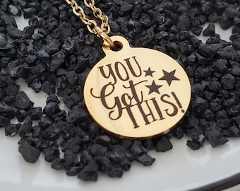 May include: Gold necklace with a round pendant that says "You Got This!" with two stars.
